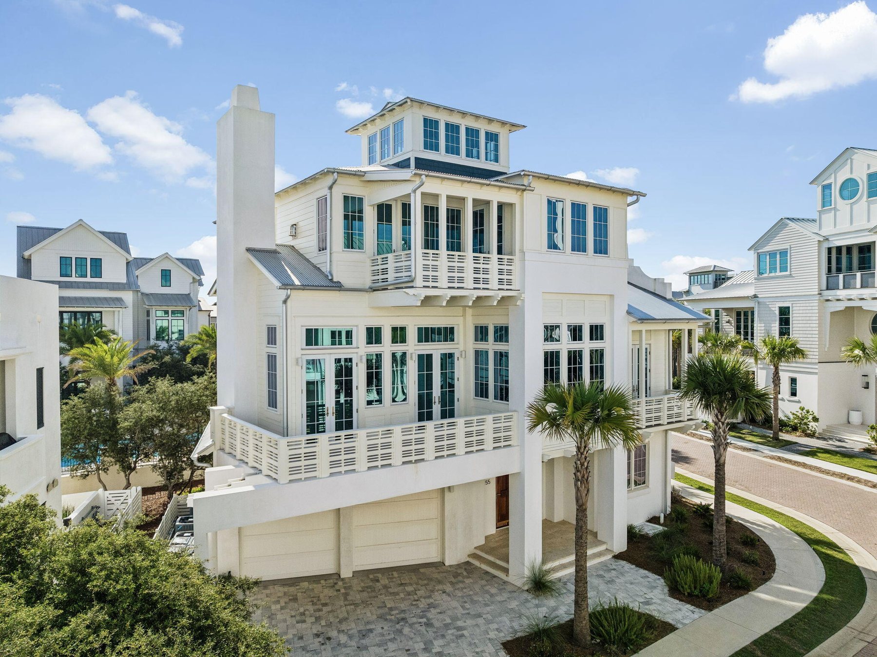 A newly built white coastal home with palms, from a 30A listing